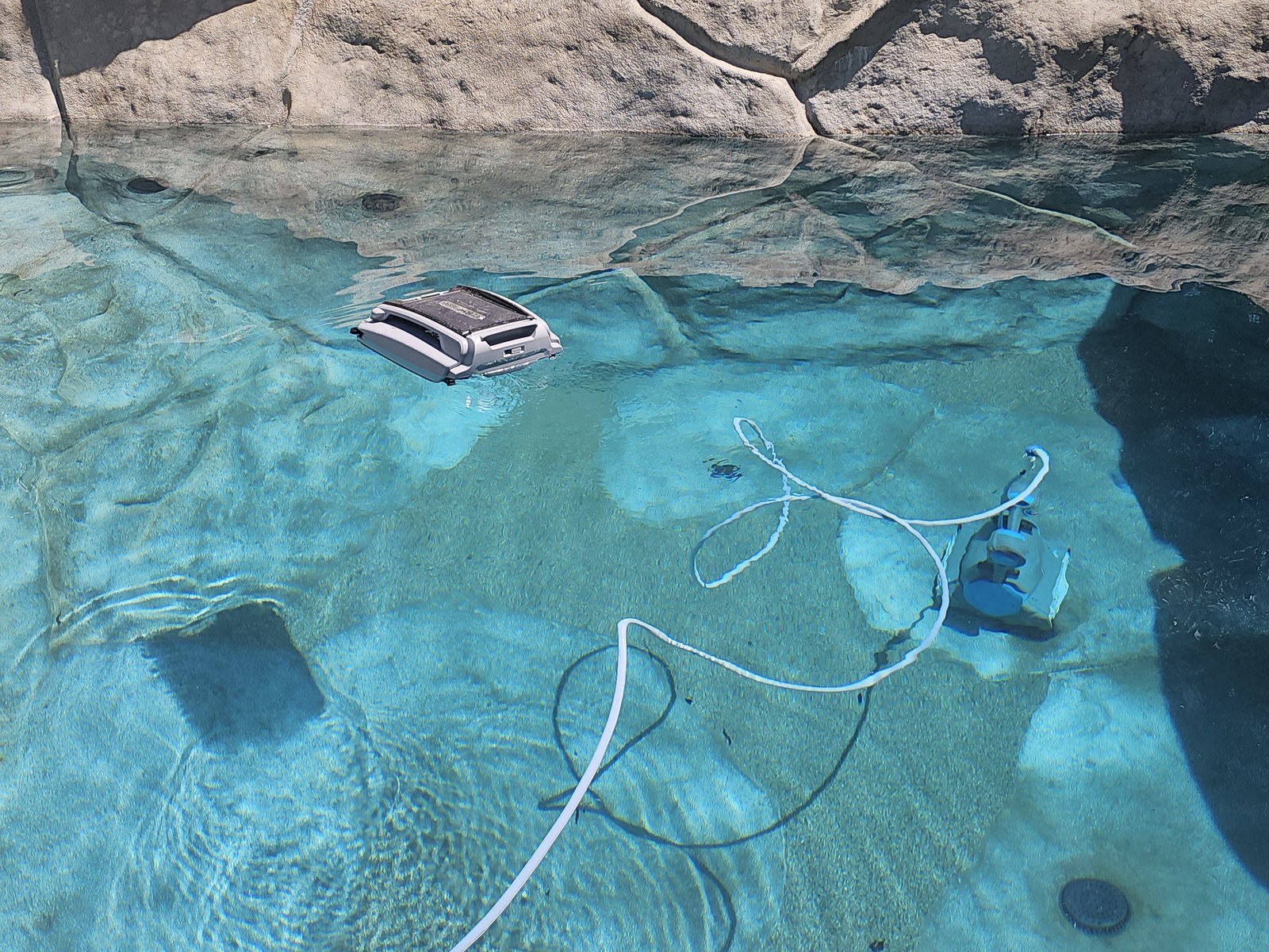SurfaceClear in action — submerged robot cord with solar skimmer operating freely